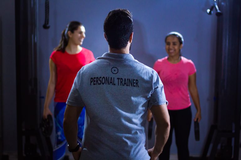 Personal trainer begeleidt klant bij fitnesstraining voor doelgerichte trainingsprogramma's